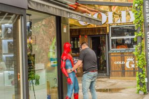 May, 2018: Unidentified man setting up Spiderman in front of store front in Itaewon
